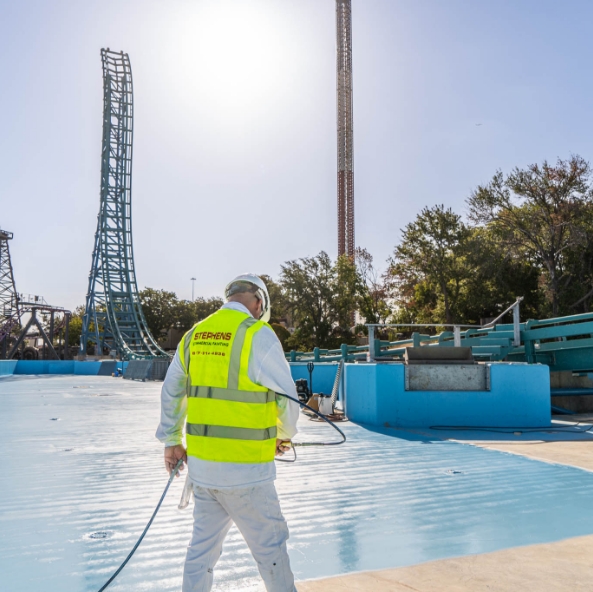 application of waterproof sealant on the bottom of a concrete pool at a theme park