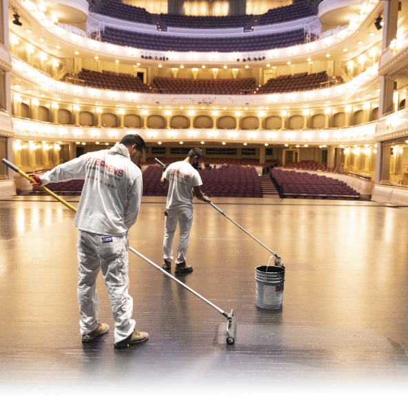painters rolling paint onto the stage of the bass performance hall in fort worth texas